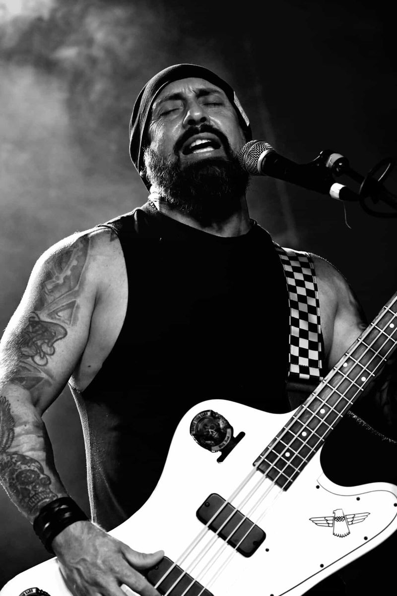 Black and white photo of Kevin singing and playing bass