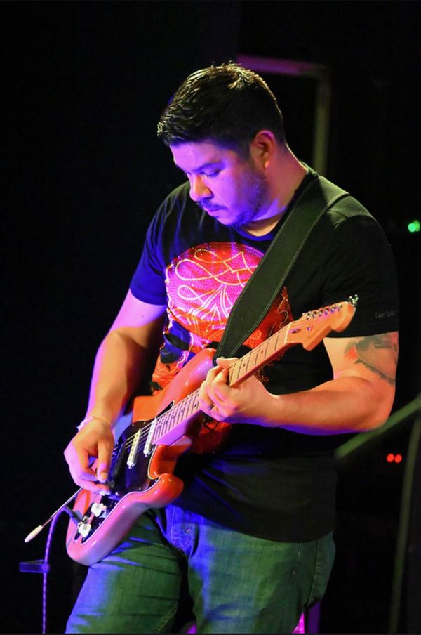 Guitarist playing a red Stratocaster