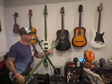 Rehearsing in a home studio with guitars on the wall